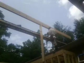 Carpenter setting a ridge beam over a new addition frame — Ice Dam Removal by Roofing Brothers in Lorane